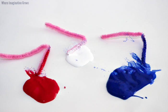 Use pipe cleaners & paint to make fireworks! A simple painting craft is that's an easy Fourth of July craft for kids!