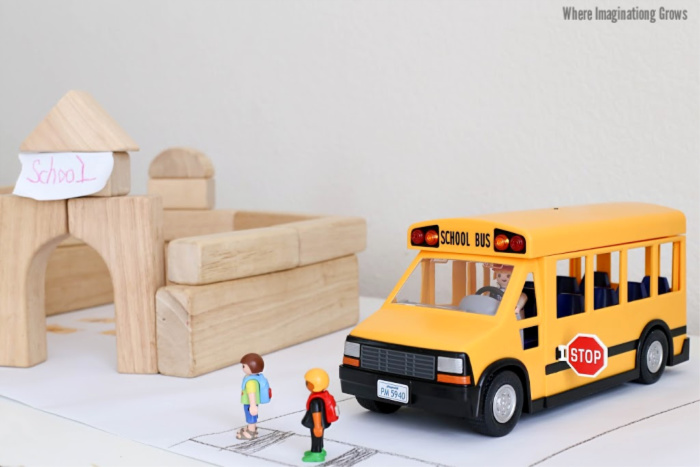 Simple school small world play for preschoolers! A hands-on school bus themed pretend play prompt with Playmobil and blocks!